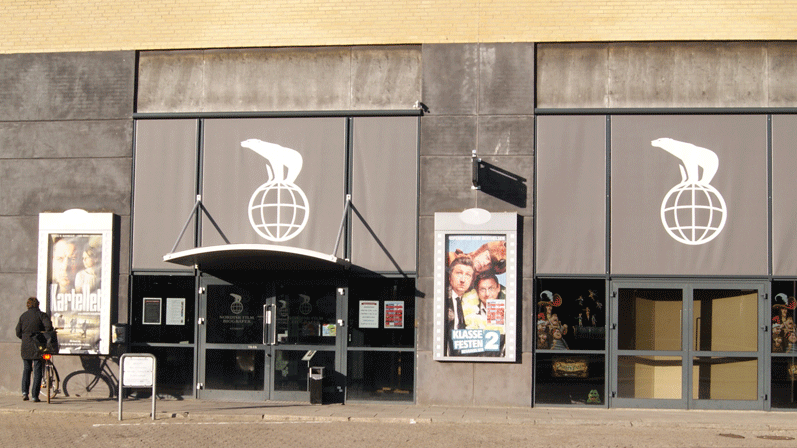 En Nordiske Film Biograd udefra med to store døre. Der hænger plakater af to film: Klassefesten 2 og Kartellet